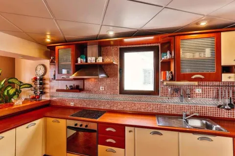 Kitchen with wooden cabinets, red tiled backsplash, and built-in appliances. - image 8