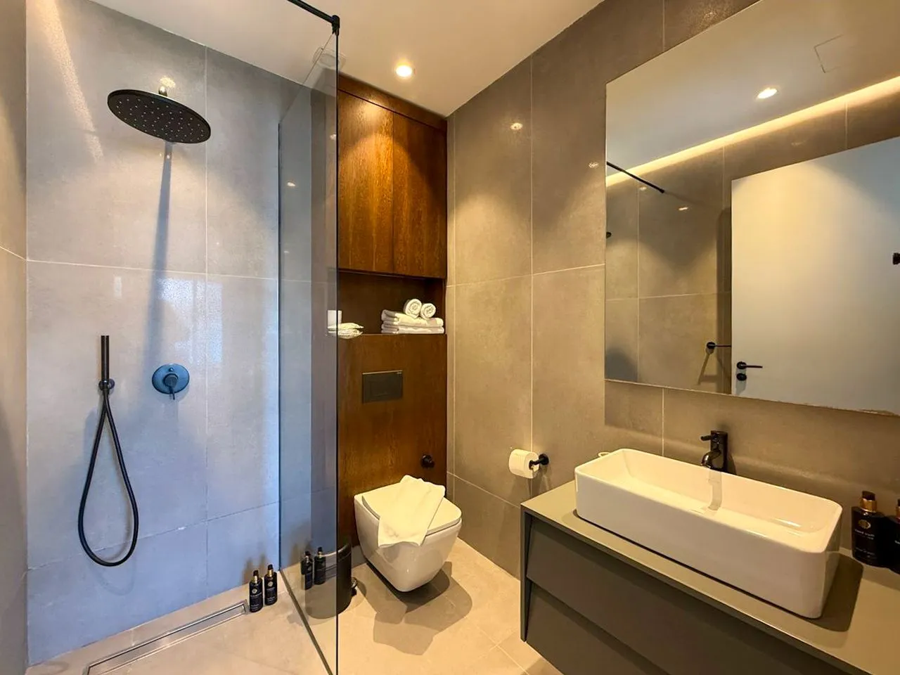 Moderno opremljeno kupatilo sa tuš kabinom, umivaonikom i wc šoljom.