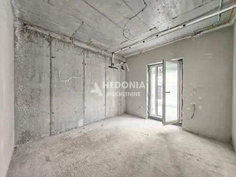 Nepotpuna prostorija u sivoj fazi sa betonskim zidovima i vratima koja vode na terasu. - image 3