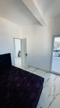 Svjetla spavaća soba sa krevetom, mermernim pločicama i izlazom na terasu. - image 4