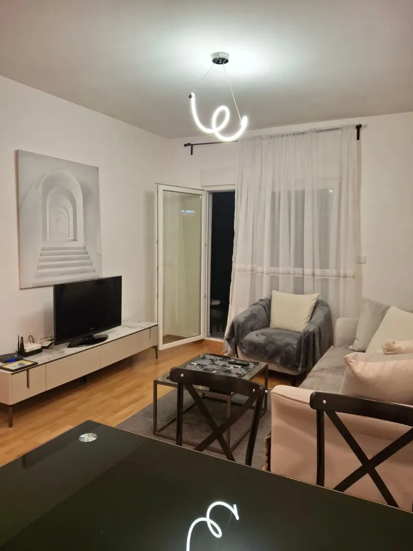 Furnished living room with a sofa set, television, and access to the terrace.