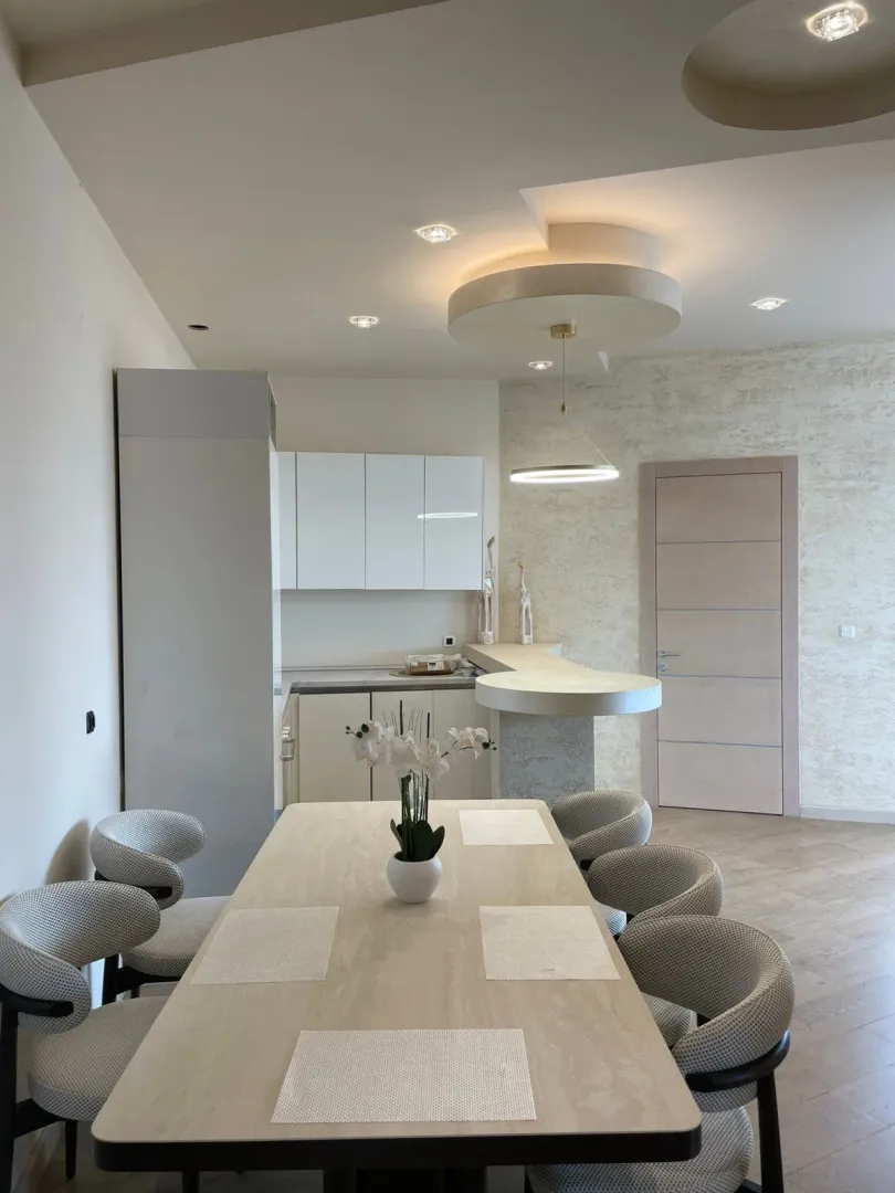 Modern dining area and kitchen with a dining table and chairs.