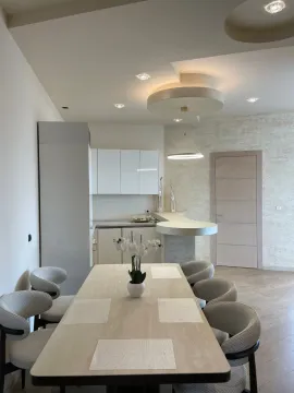 Modern dining area and kitchen with a dining table and chairs. - image 4