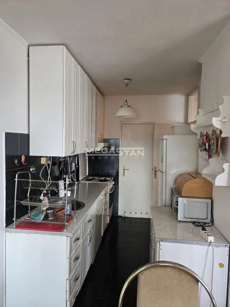 Manja kuhinja sa belim elementima i belom tehnikom.