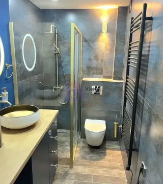 Moderno opremljeno kupatilo sa tuš kabinom, umivaonikom i WC šoljom. - image 7