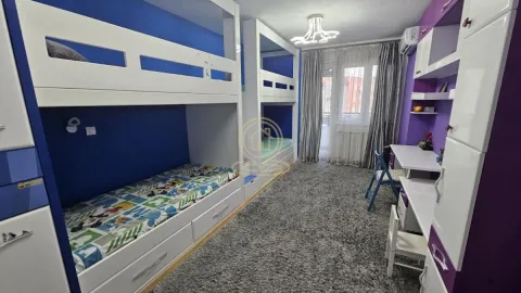 Children's bedroom with two bunk beds, a desk, and blue and purple walls. - image 2