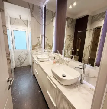 Luxuriously equipped bathroom with two washbasins and marble tiles. - image 10