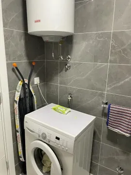 Kupatilo sa mašinom za veš i bojlerom na zidu. - image 9