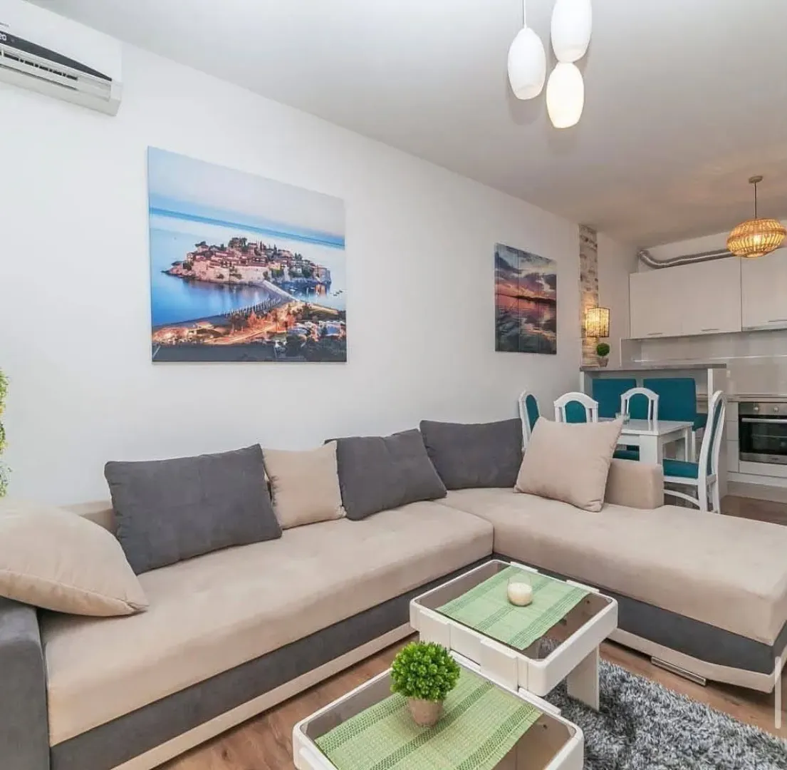 Living room with a sectional sofa and a dining area in the background.