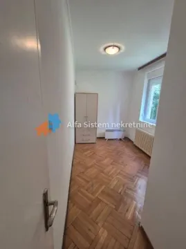 View from the hallway into a smaller room with parquet flooring and a wardrobe. - image 12