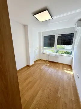 Empty bright room with parquet flooring and a large window. - image 6