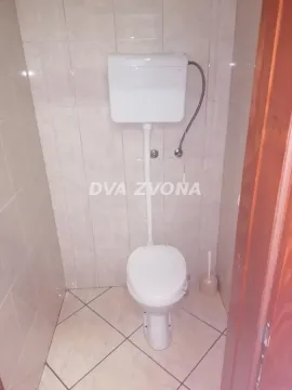 Small bathroom tiled with ceramic tiles containing a toilet. - image 10