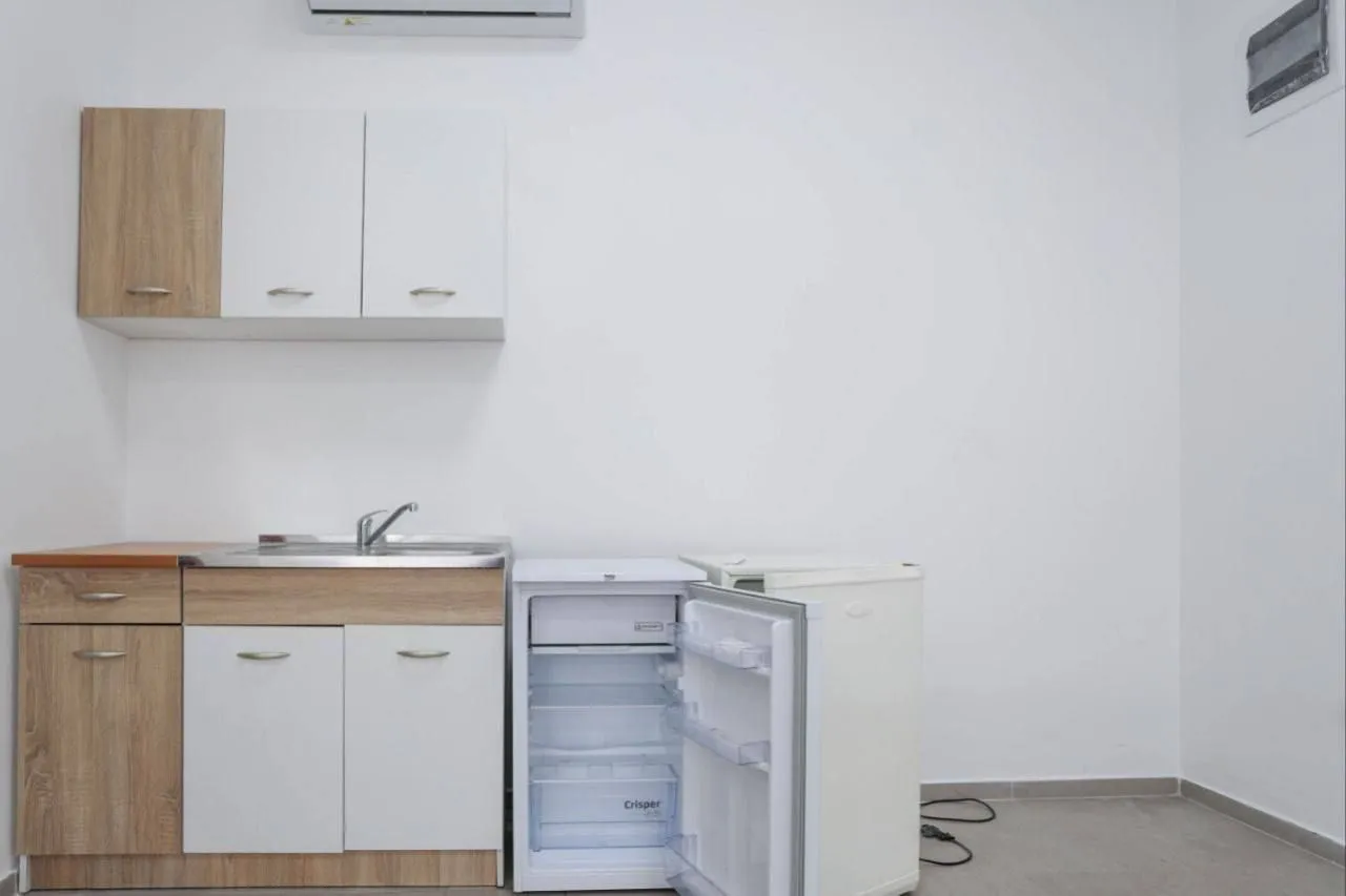 Smaller kitchen with cabinetry and a refrigerator.