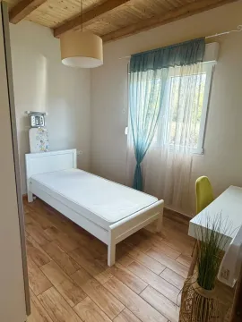 Bright bedroom with a white bed, desk, and a window. - image 6