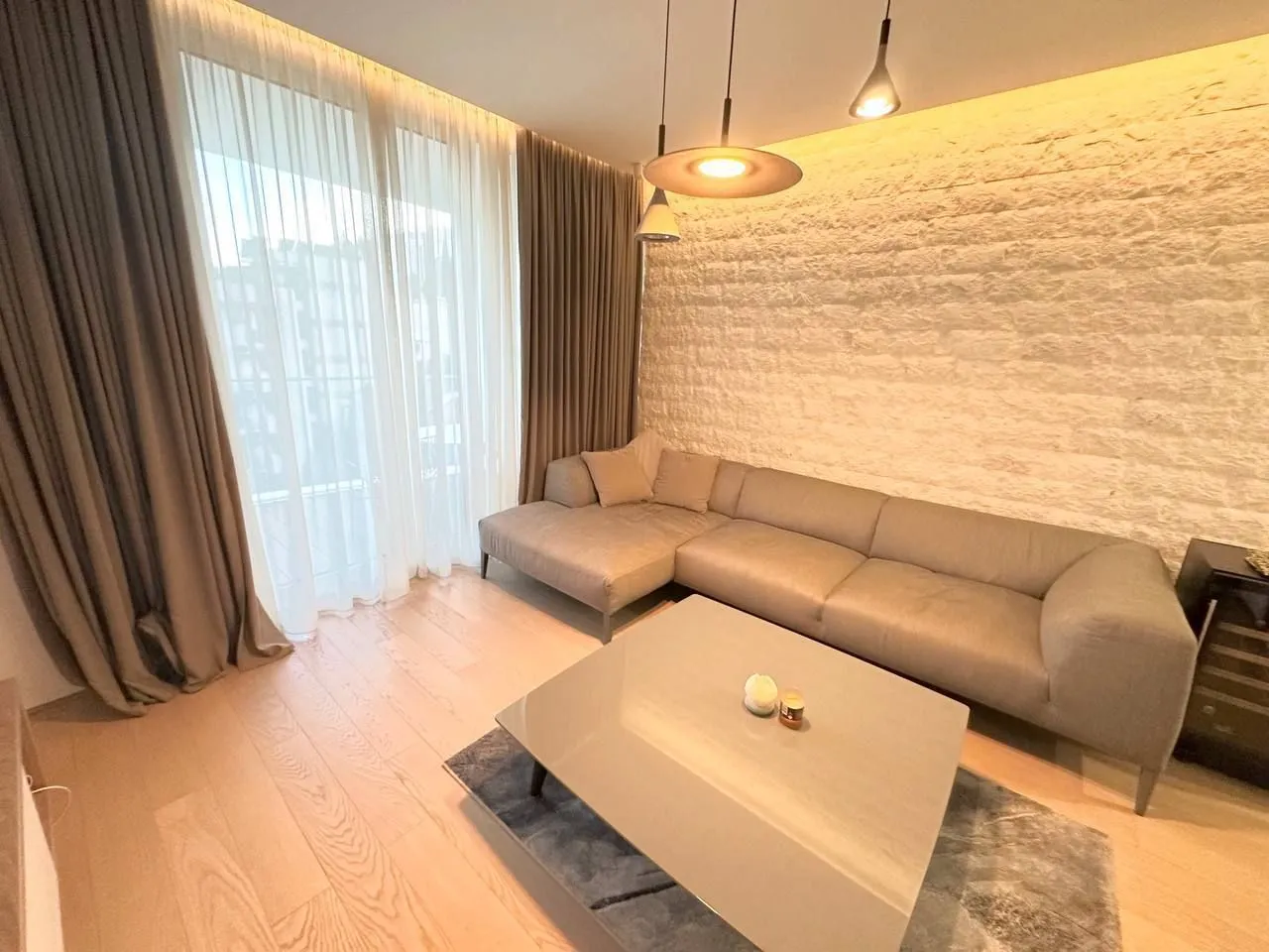 Modern living room with a sofa, coffee table, and decorative stone wall.