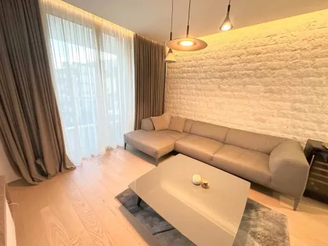 Modern living room with a sofa, coffee table, and decorative stone wall. - image 2