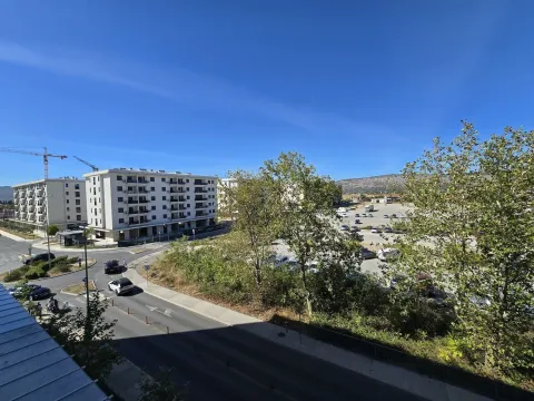 View from the terrace overlooking surrounding buildings, street, and parking lot. - image 14