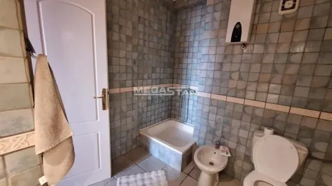 Manje kupatilo obloženo pločicama sa kadom, wc šoljom i bideom. - image 17
