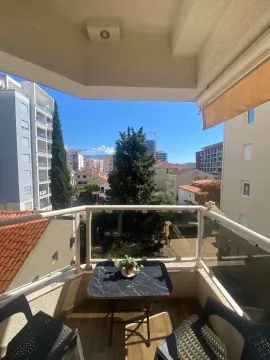 Namještena terasa sa stočićem i pogledom na gradsko okruženje. - image 9