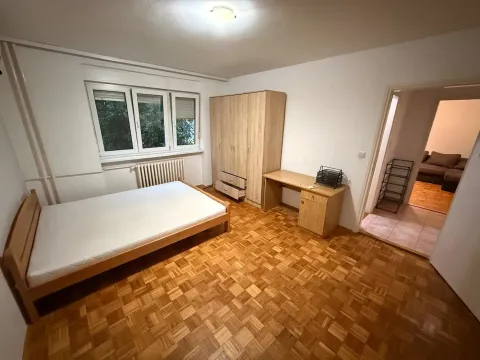 Nameštena spavaća soba sa drvenim podom, ormanom i krevetom. - image 3