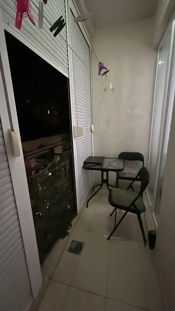 Manji zatvoreni balkon sa stolom i dve stolice.