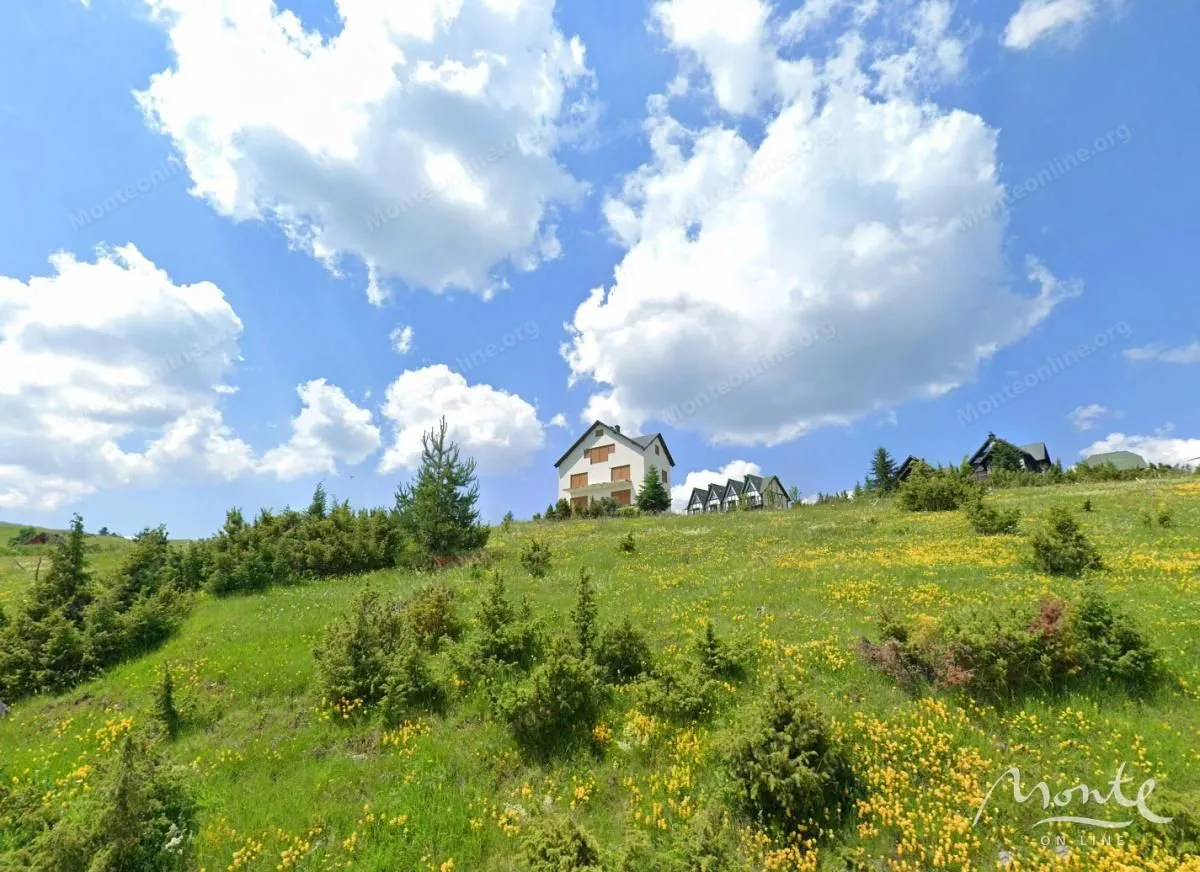 Pogled na kuću sa travnatog imanja i okoline u prirodi.
