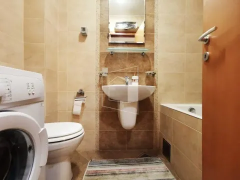 Compact bathroom with a sink, toilet, bathtub, and washing machine. - image 9