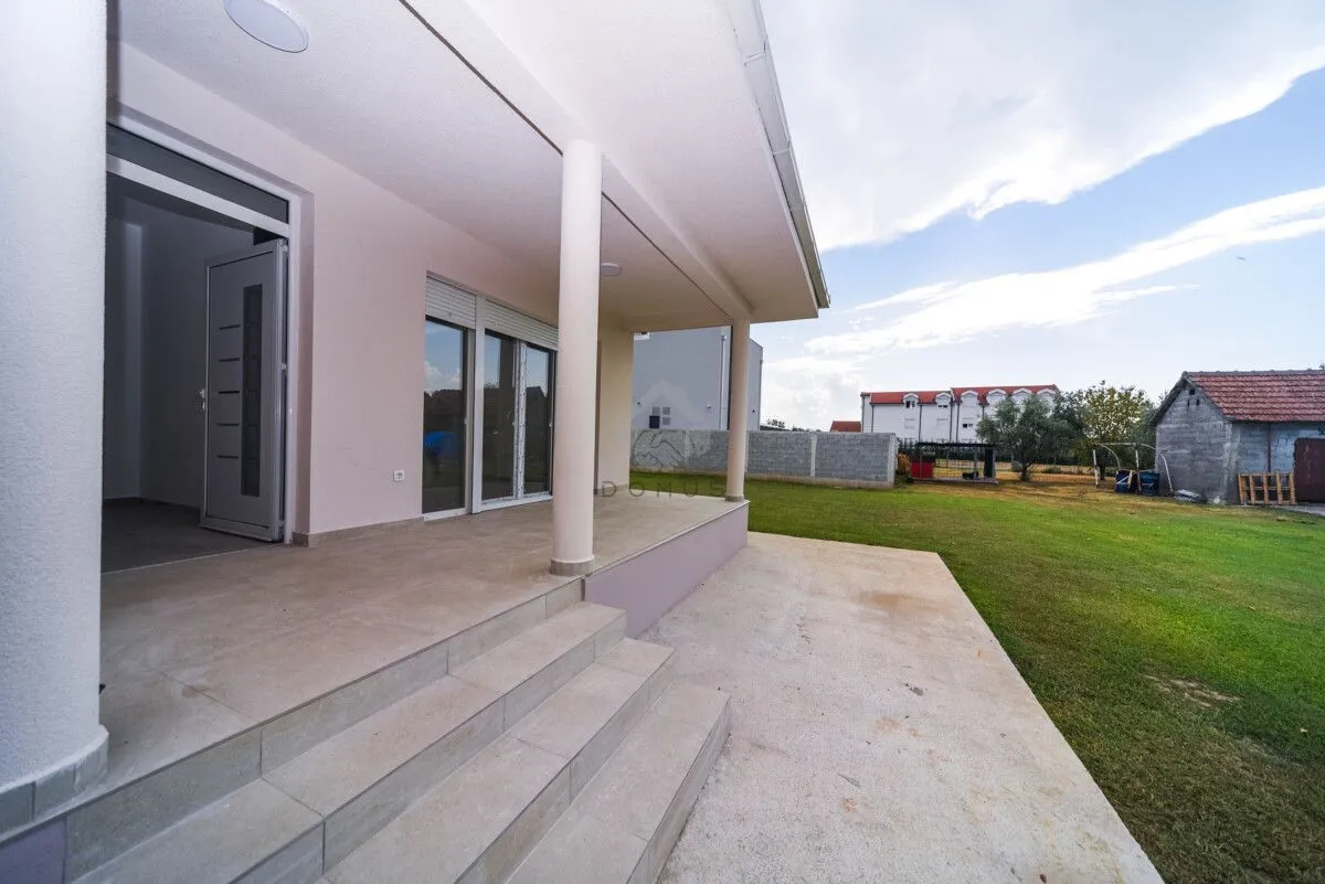 Covered terrace and house entrance with a view of the yard.