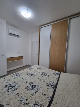 A bright bedroom featuring a built-in wardrobe and air conditioning. - image 5