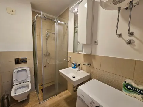 Bathroom with a shower cabin, washbasin, and toilet. - image 5