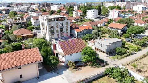 Pogled iz vazduha na stambeni objekat i okolno naselje sa kućama i zgradama. - image 4