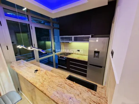 Kitchen with a breakfast bar and built-in appliances - image 7