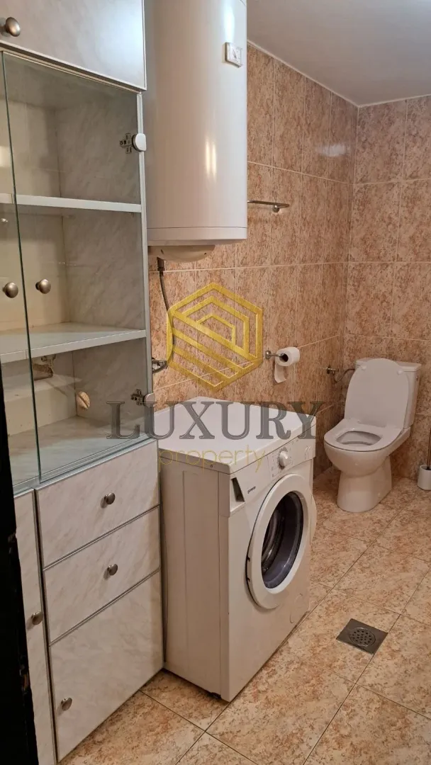 Manje kupatilo sa veš mašinom, bojlerom i WC šoljom.