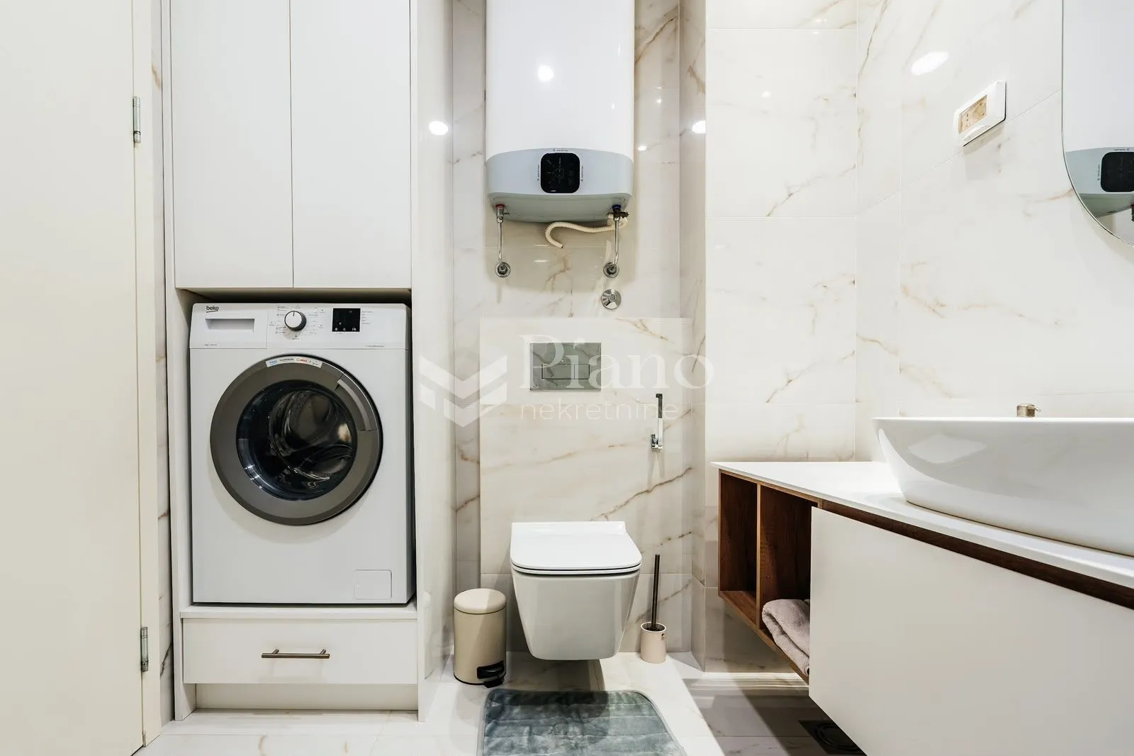Modern bathroom with a washing machine, built-in cabinet and sanitary ware.