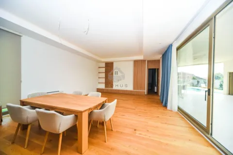 Spacious living room with a wooden dining table and chairs, and large glass doors leading to the terrace. - image 16