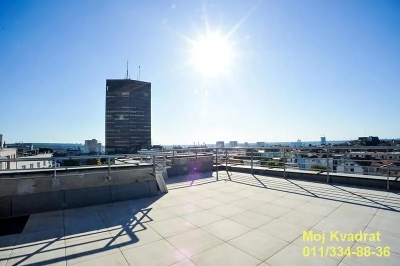 Large spacious terrace with a view of the city and a high-rise building.