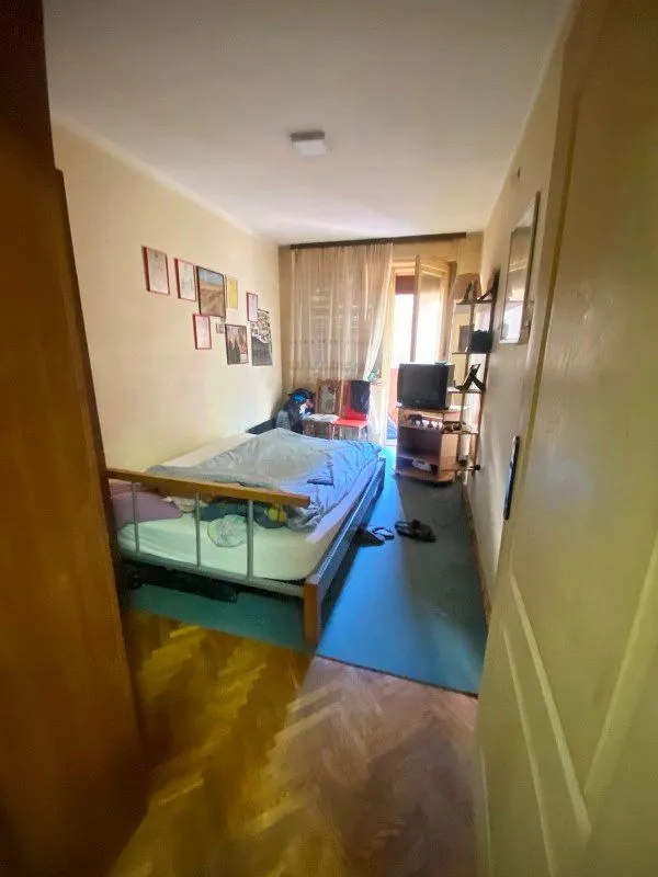 Nameštena spavaća soba sa krevetom i televizorom.