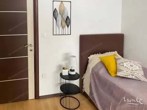 Manja spavaća soba sa krevetom i noćnim stočićem. - image 10