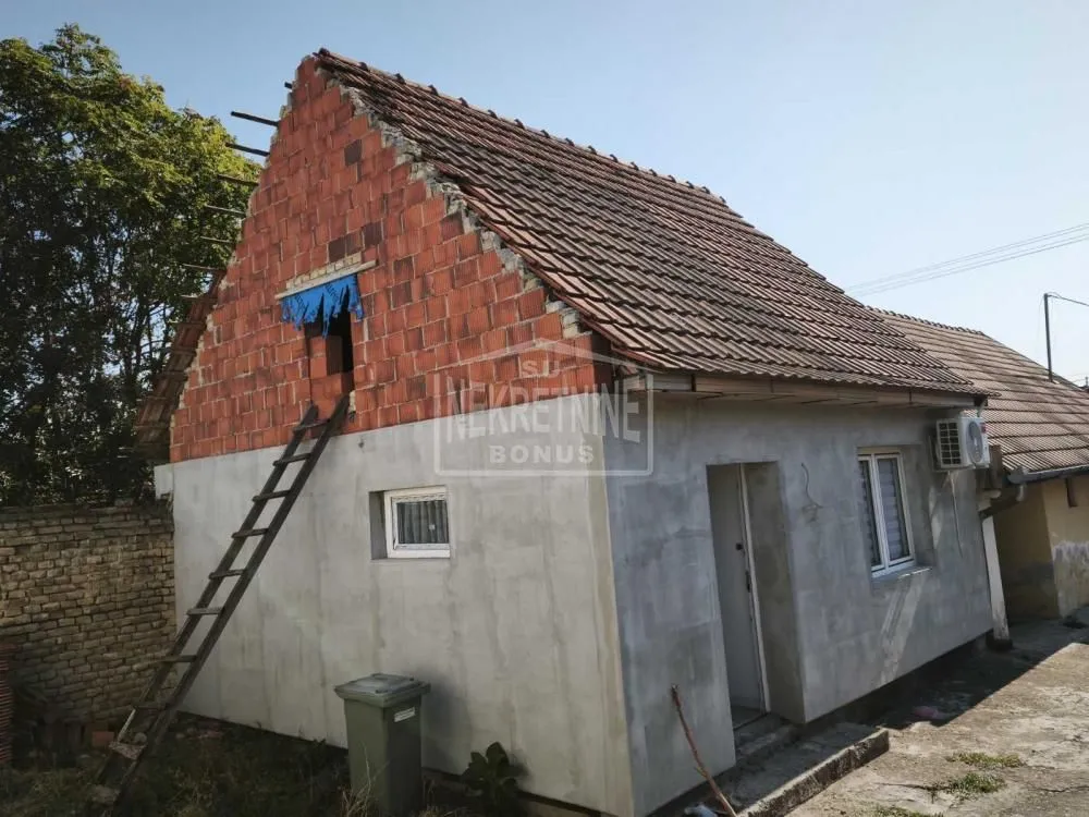 Pogled na spoljašnjost kuće u izgradnji sa krovom od crepa.