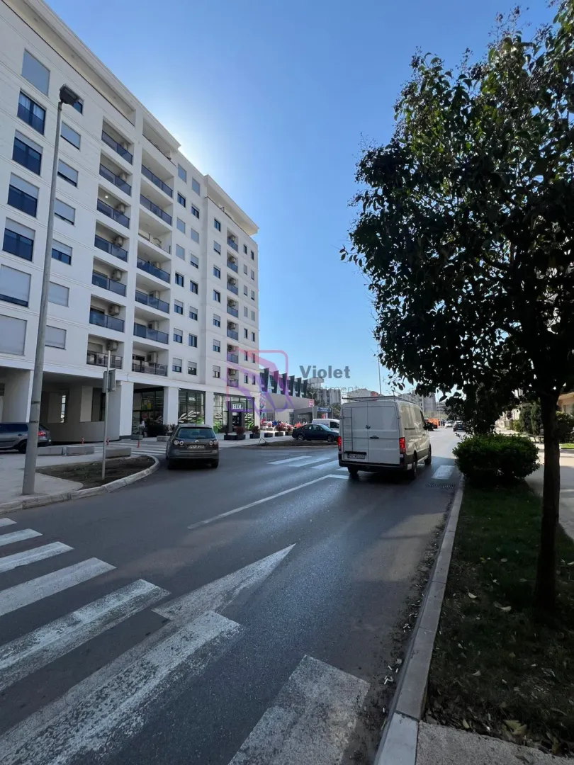 Pogled na ulicu i spoljašnjost stambene zgrade.