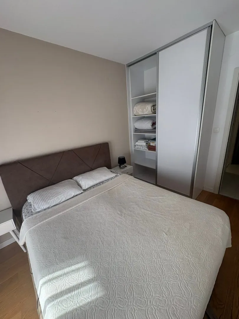 Furnished bedroom with a double bed and a built-in wardrobe.