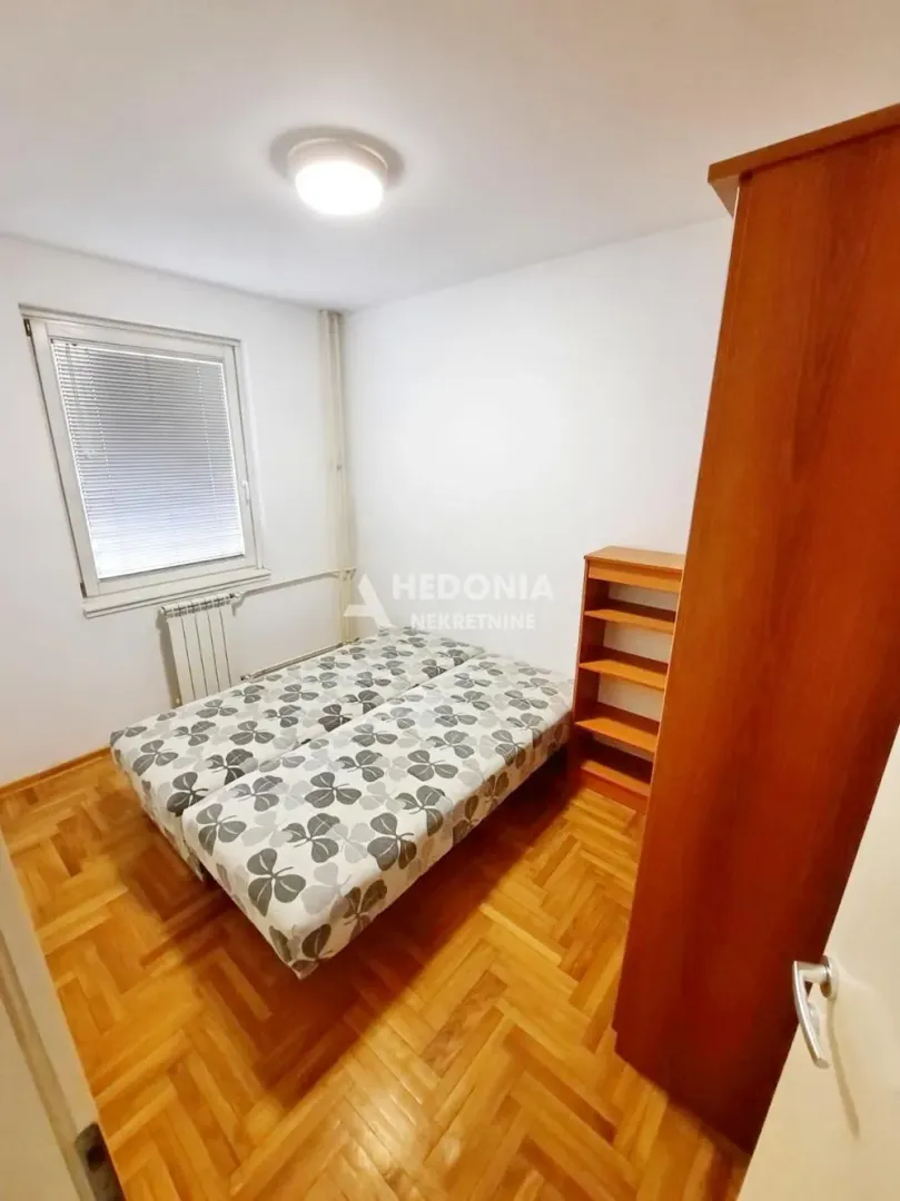 Smaller bedroom with a bed, wooden flooring, and a wardrobe.
