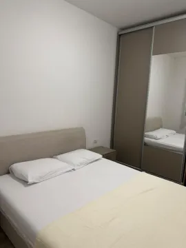 Furnished bedroom with a double bed and a built-in wardrobe with a mirror. - image 6