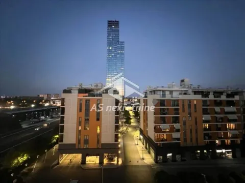 View from the apartment overlooking modern residential buildings and a skyscraper at dusk. - image 8