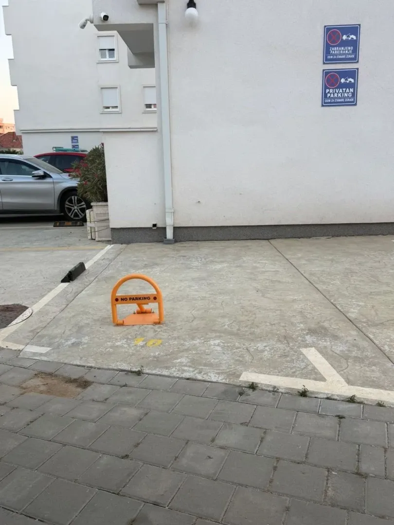 Marked parking space in front of the residential building.