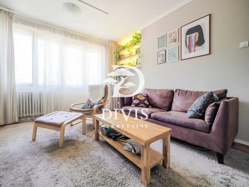 Living room with a sofa, armchair and wooden coffee table by the window.