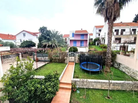 Pogled na dvorište i okolne kuće sa zelenilom i palmom. - image 8