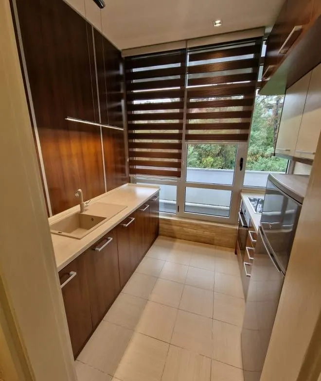 Small kitchen with dark wooden cabinetry and a built-in refrigerator.