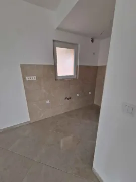 Nekنامještena kuhinja sa pločicama na zidu i podu i prozorom. - image 3