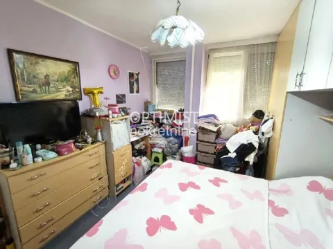 Nameštena spavaća soba sa krevetom, komodom i televizorom. - image 7